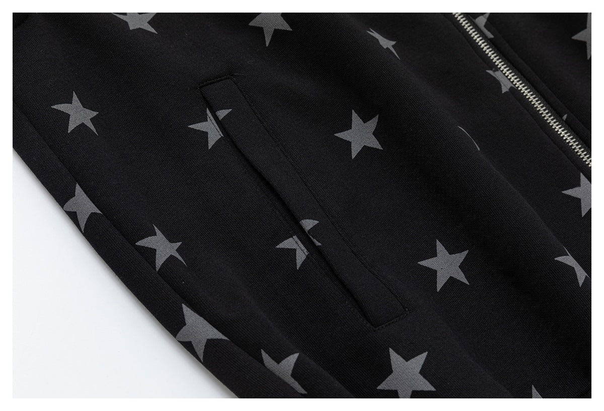 Close-up of a black jacket's gray star print and narrow welt pocket beside the silver front zipper.