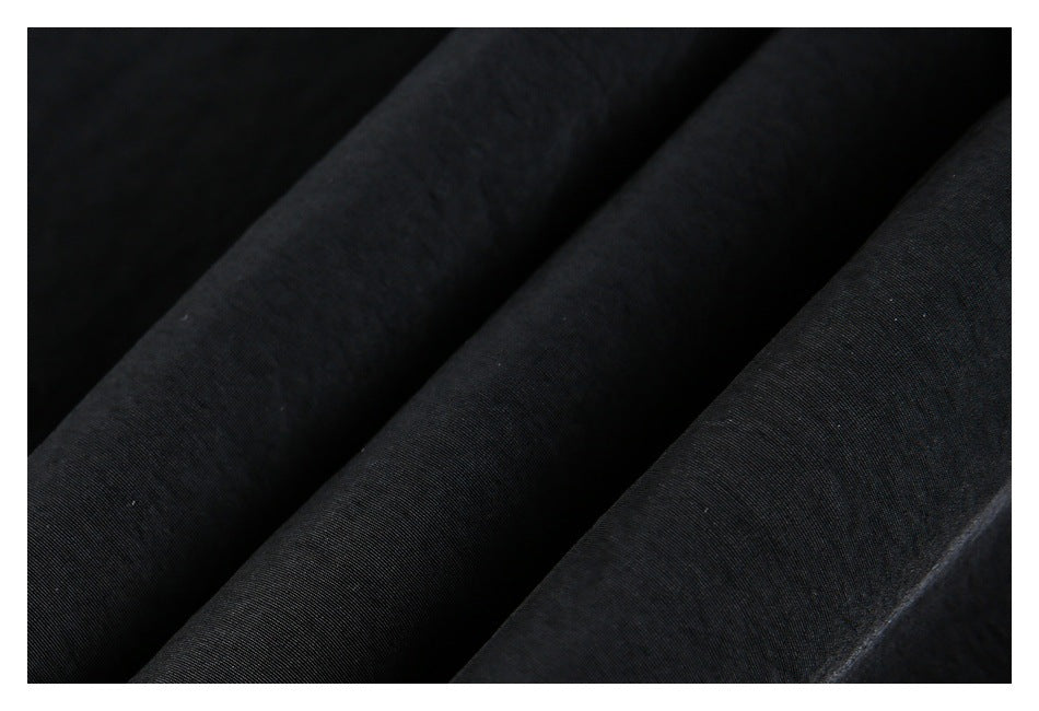 Close-up showing the dark, subtly textured surface of black garment fabric.