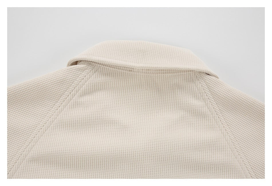 Close-up of the cream waffle-textured garment's collar and upper back.