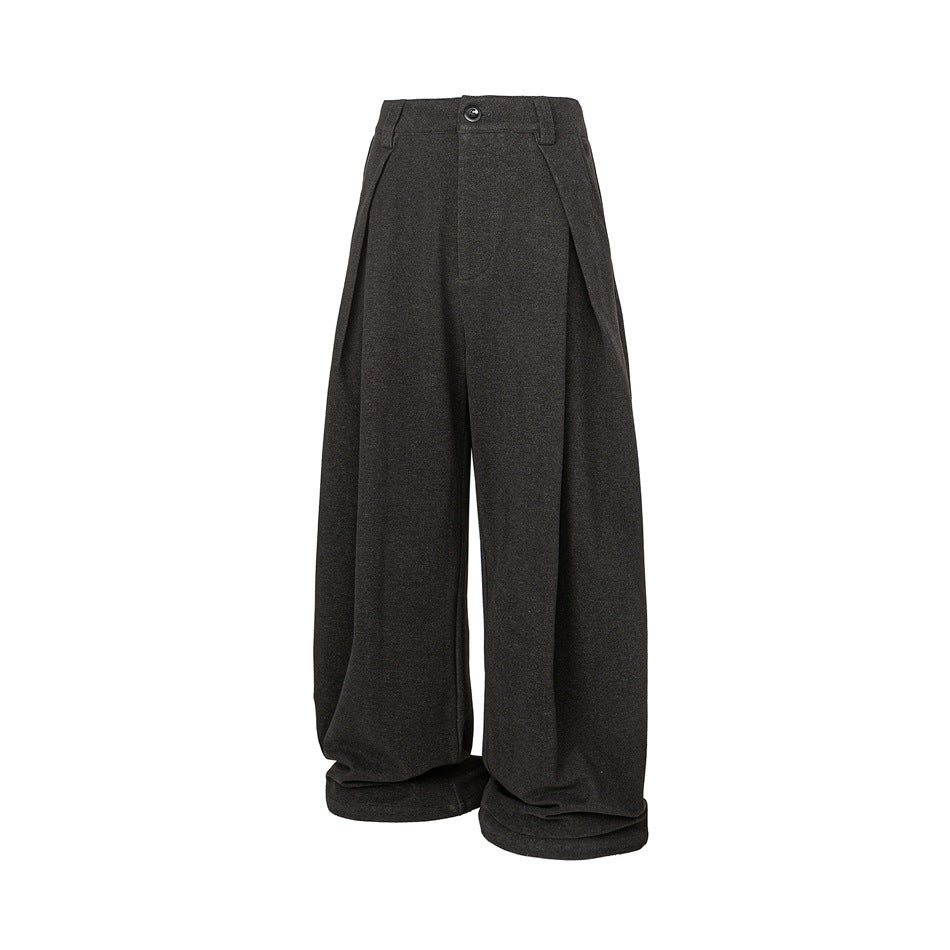 Black wide-leg pleated trousers with a front button, belt loops, large front pleats and gathered cuffed hems