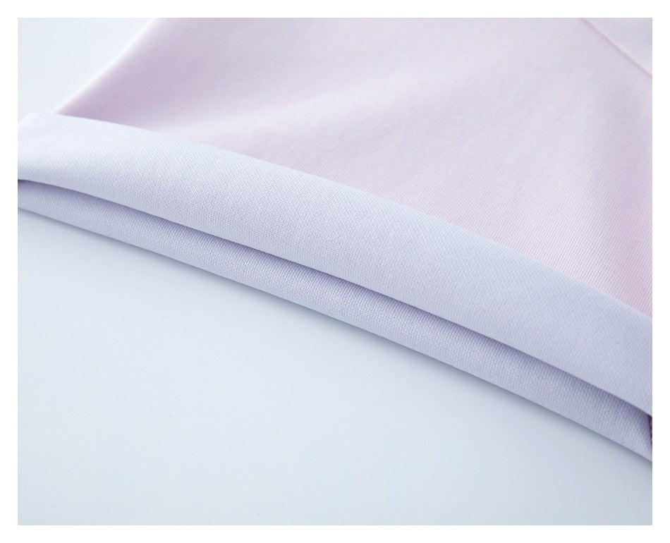 Close-up of the pale pink T-shirt hem folded to show its light-colored inner side.