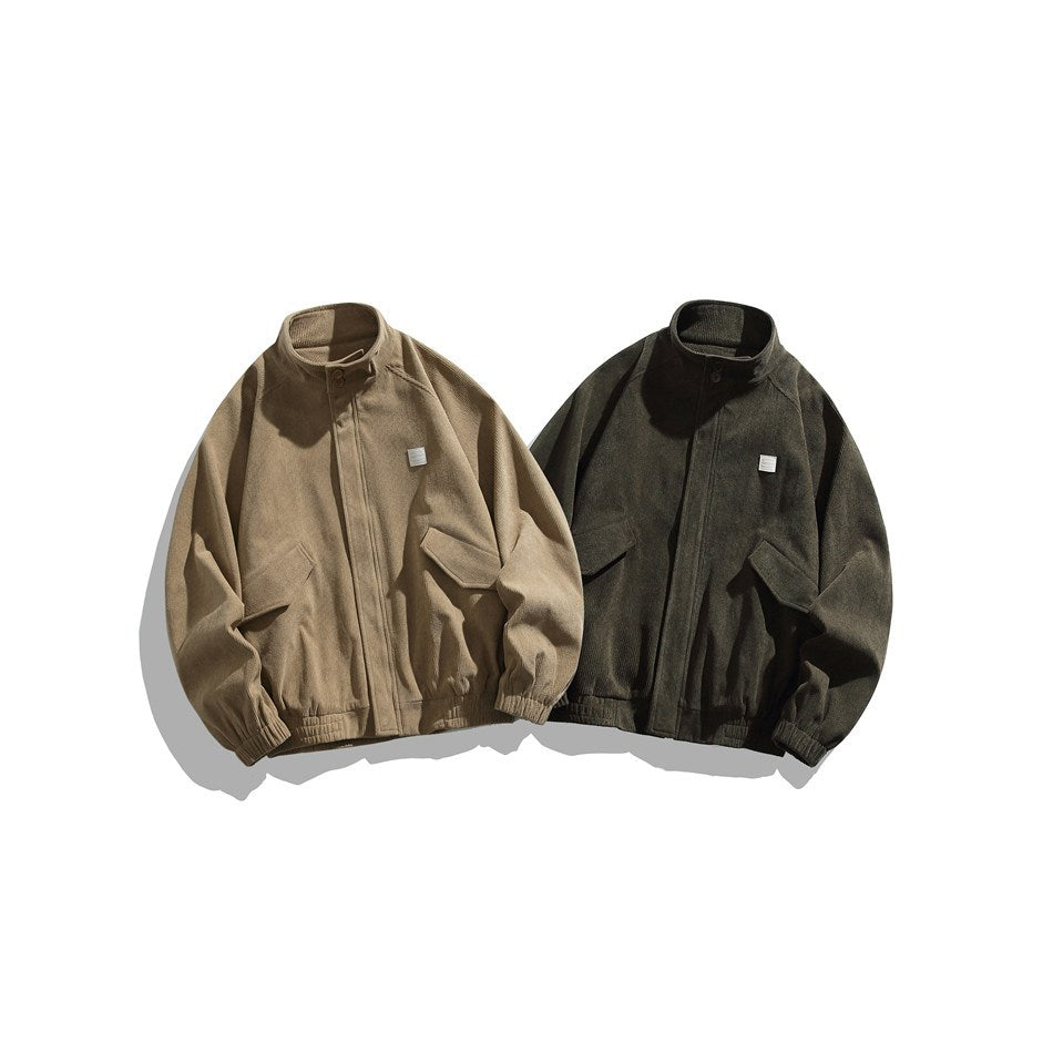 Two front-view jackets with raised collars, zip closures, flap pockets, and elastic hems in tan and dark olive.