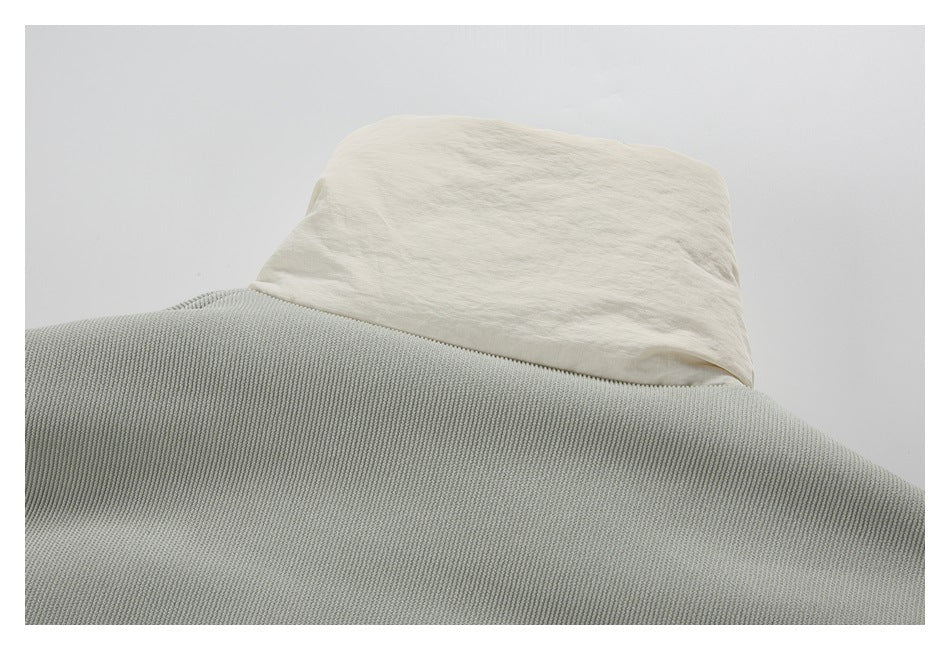 Close-up of a cream collar above the gray ribbed upper back of a garment.