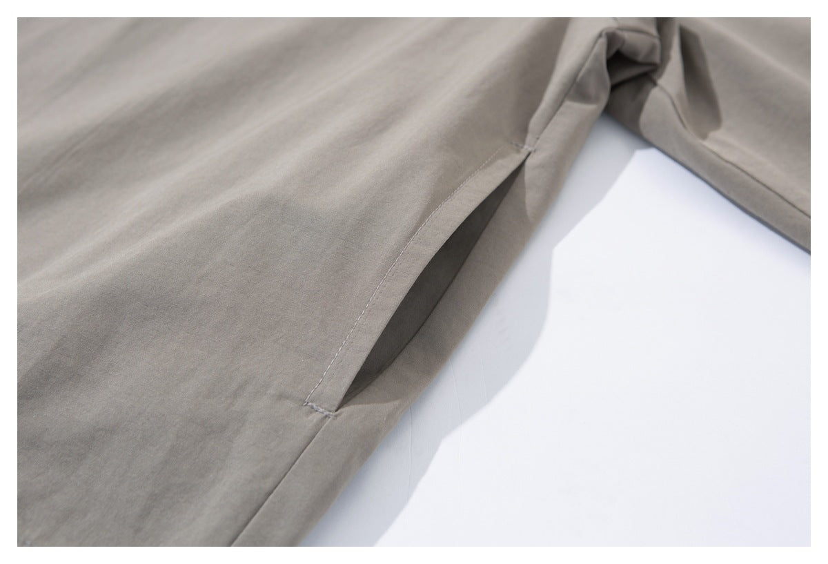 Close-up of the taupe-gray jacket's side seam and pocket opening.