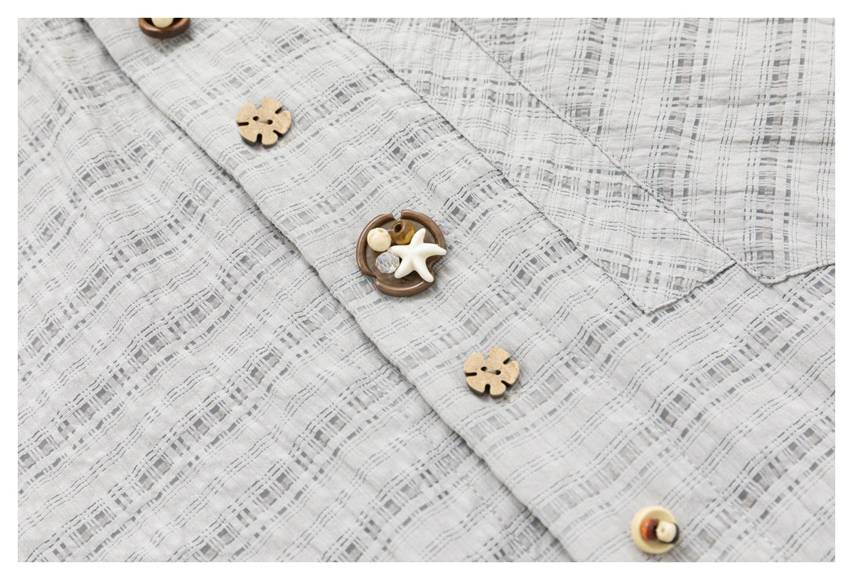 Close-up of a light gray checked shirt placket with decorative wood-tone buttons.