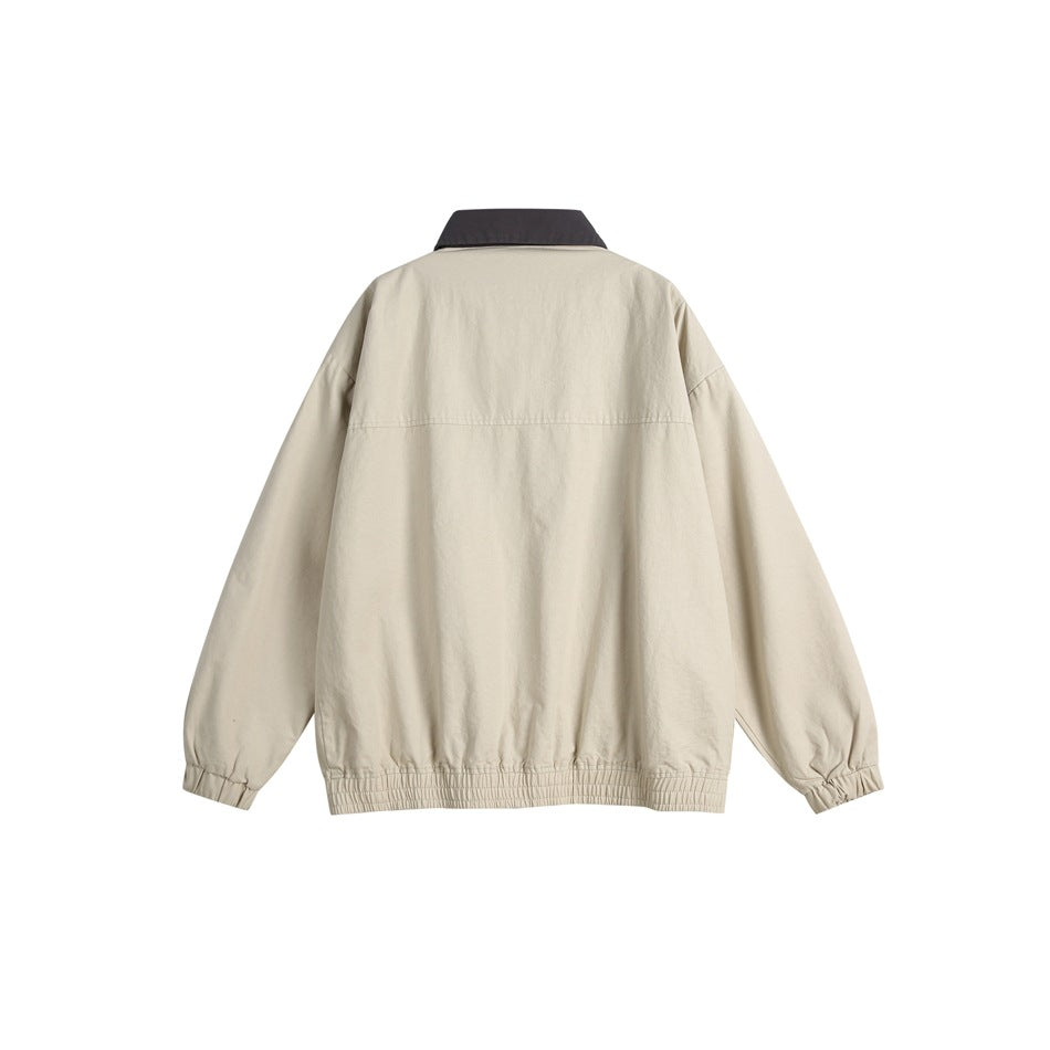 Back view of a light beige jacket with a dark charcoal collar, long sleeves, and elastic cuffs and hem.