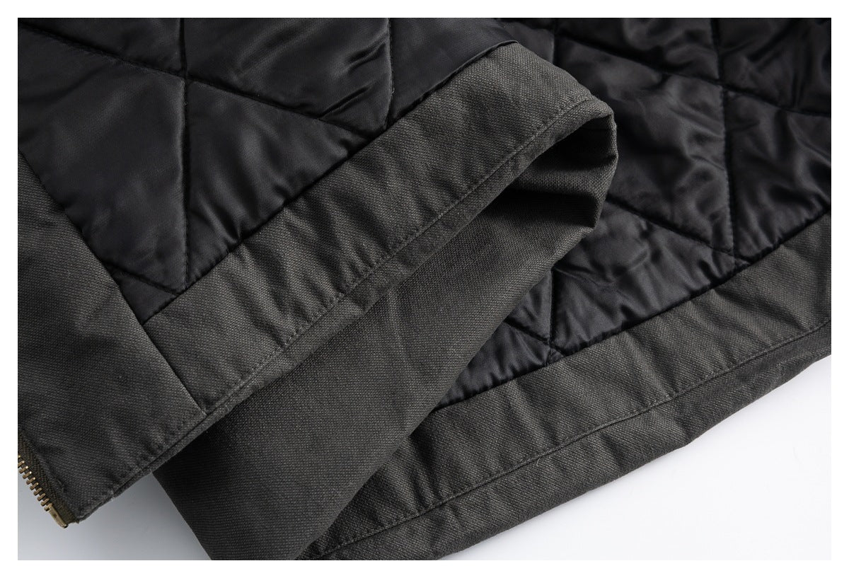 Close-up of the dark jacket's quilted black lining, outer fabric and stitched hem.