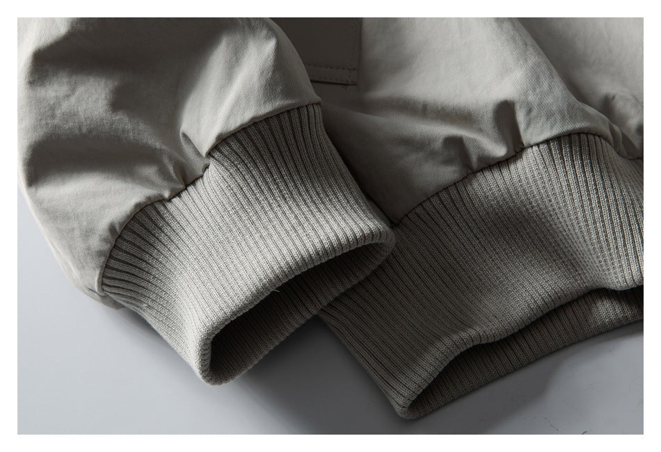 Close-up of the pale gray jacket's rib-knit sleeve cuff and gathered sleeve fabric.