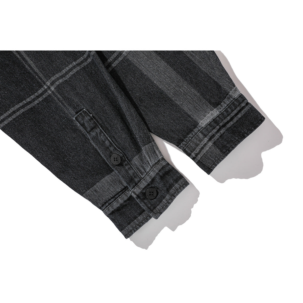 Close-up of dark plaid shirt sleeves and buttoned cuffs.