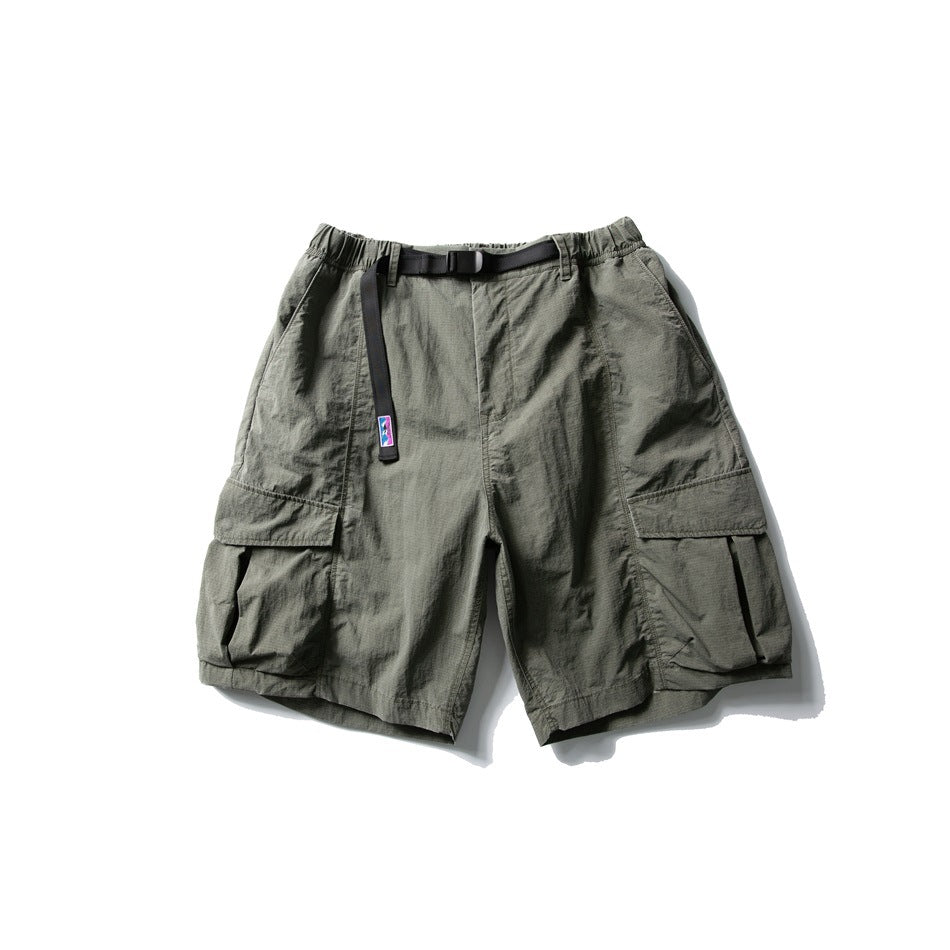 Sand green cargo shorts with elastic waist, black buckle belt and large flap thigh pockets, flat lay front view