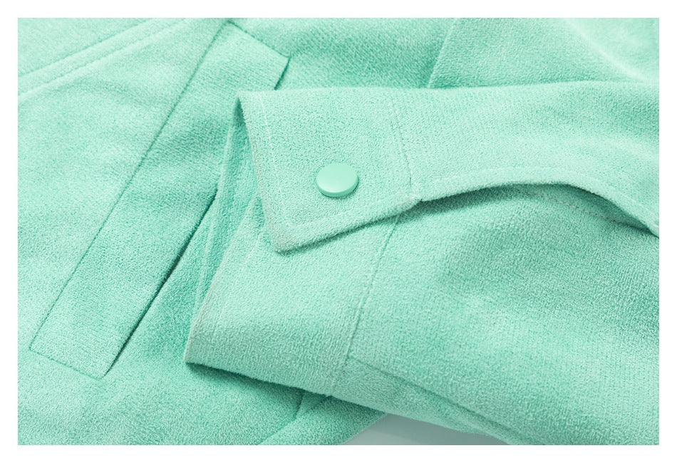 Close-up of a mint-green sleeve cuff with a matching snap button and nearby seam details.