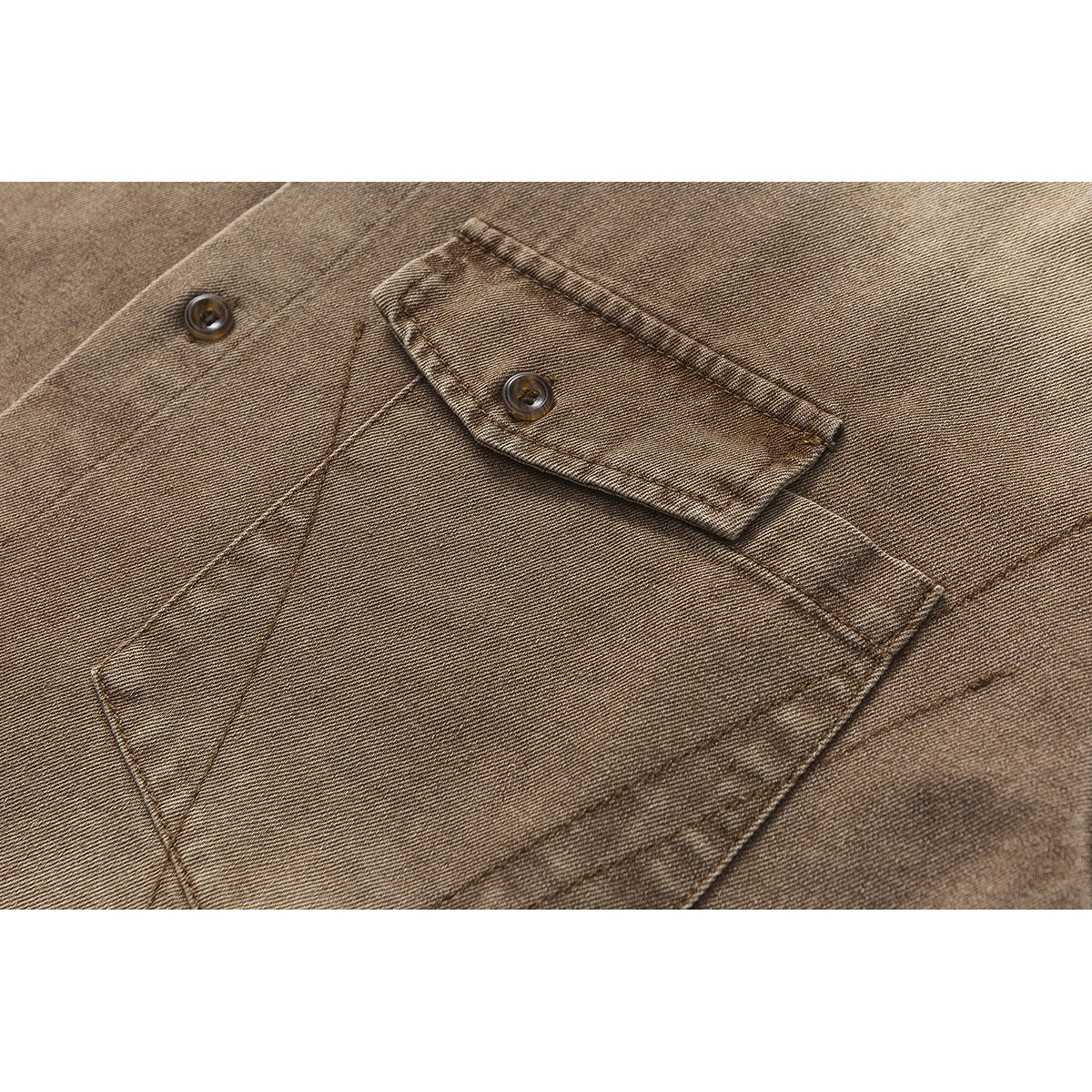 Close-up of a brown washed shirt's buttoned chest pocket and stitching.