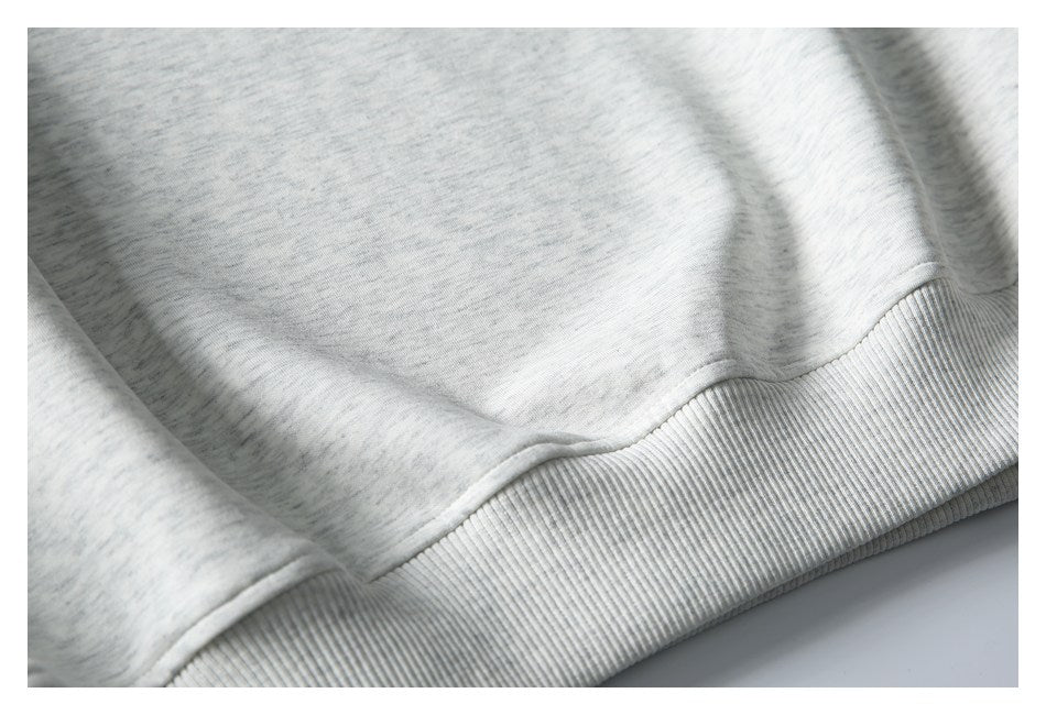 Close-up of the ribbed hem and heather gray knit fabric of a garment.