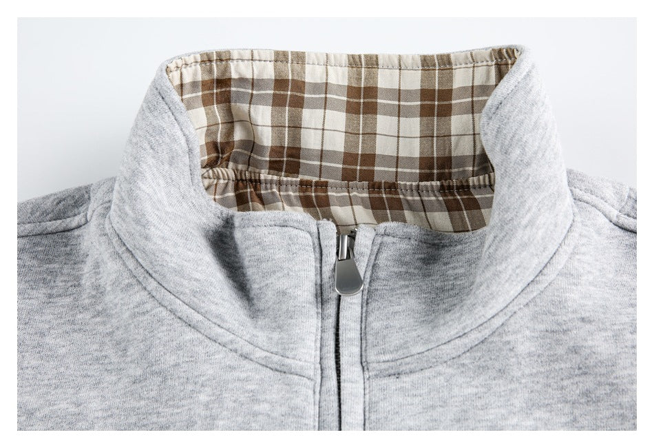 Close-up of a heather gray jacket collar with brown-and-cream plaid lining and a front zipper.