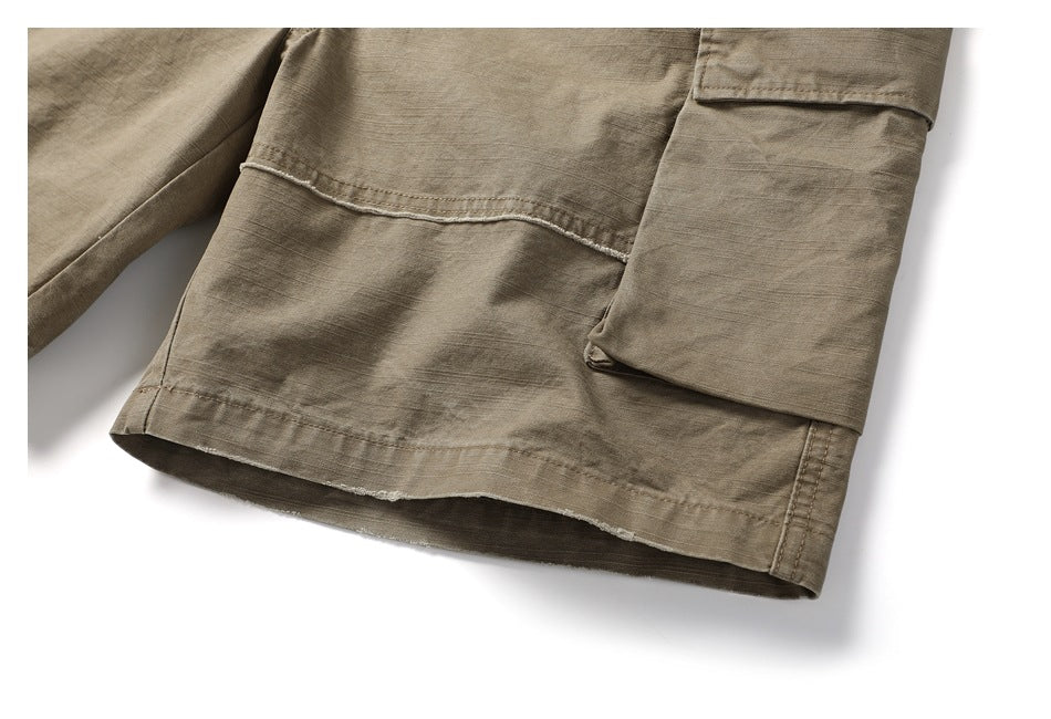 Close-up of the taupe shorts leg, showing a flap cargo pocket, stitched panel, and hem.