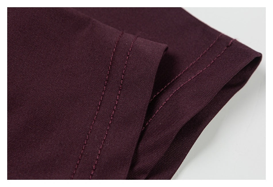 Close-up of the dark burgundy T-shirt sleeve edge and stitched hem.