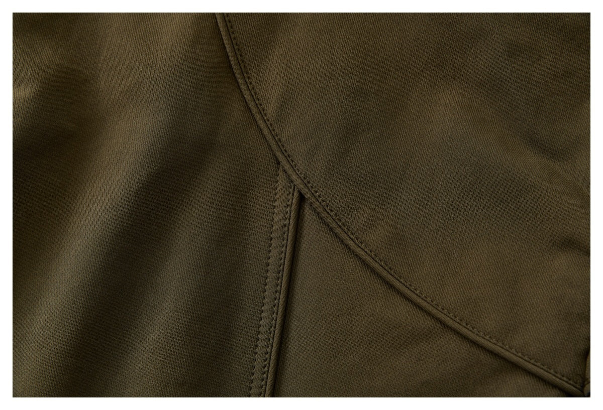 Close-up of olive-brown garment fabric with curved double-stitched seams.