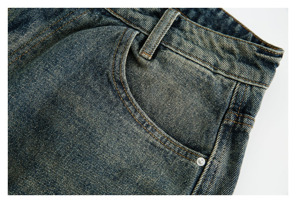 Close-up of a faded denim pocket, belt loop, and contrasting stitching.