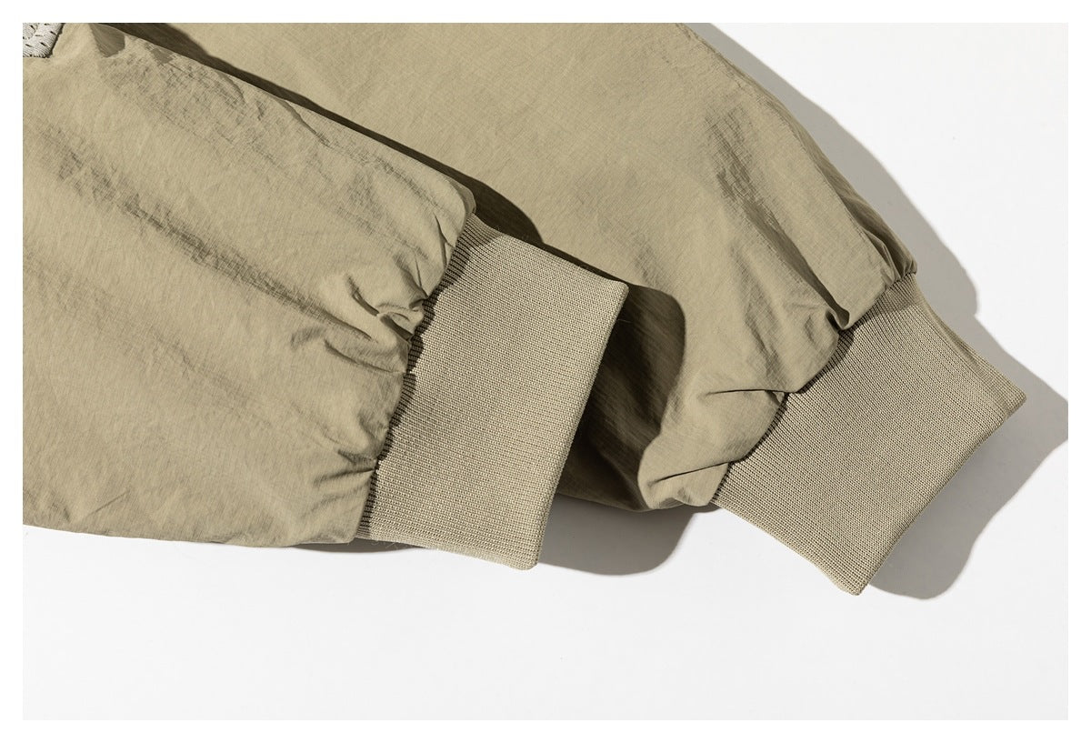 Close-up of the khaki jacket's gathered sleeves and wide ribbed knit cuffs.