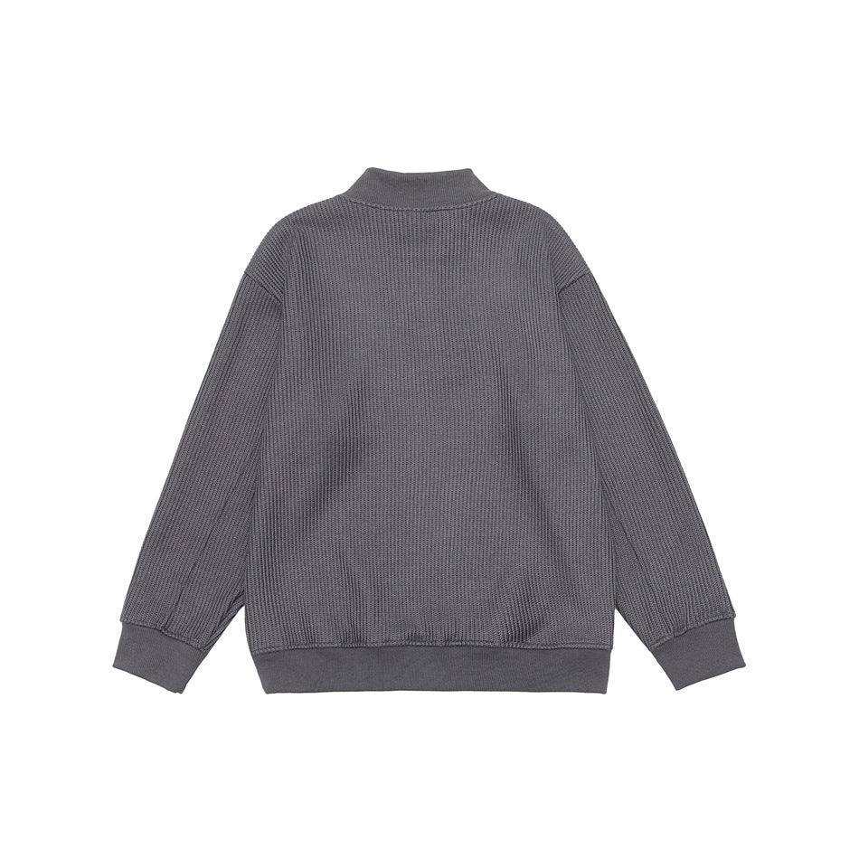 Back view of a charcoal gray textured sweater with a stand collar, long sleeves and ribbed cuffs and hem.