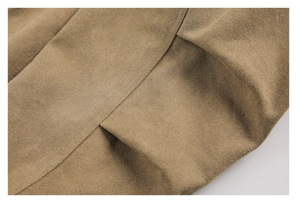 Close-up of tan woven garment panels with a curved seam and gathered fabric.