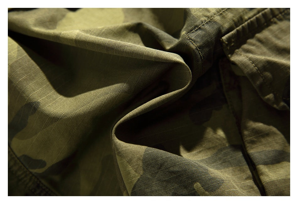 Close-up showing the ripstop-like grid texture and folds of olive camouflage fabric.