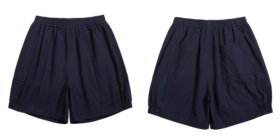 Navy loose shorts shown from front and back, with an elastic waist and two rear patch pockets.