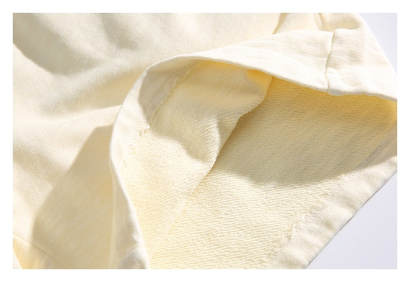 Close-up of the cream garment's interior fabric and stitched hem.