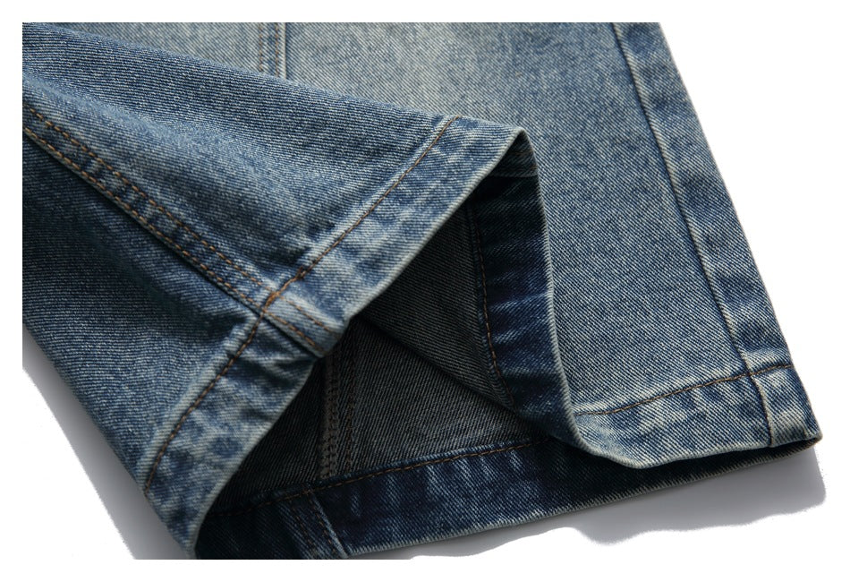 Close-up of a turned-up blue denim shorts hem showing the dark inner side and stitching.