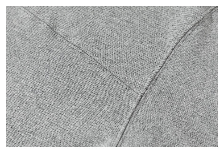 Close-up of gray sweatshirt fabric and intersecting stitched seams.