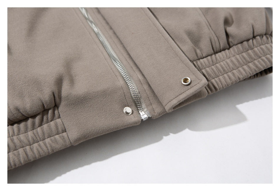 Close-up of the taupe jacket's front zipper, snap placket, and gathered elastic hem.