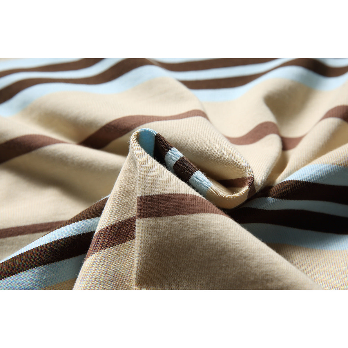 Close-up of beige T-shirt fabric with wavy brown and light blue horizontal stripes.