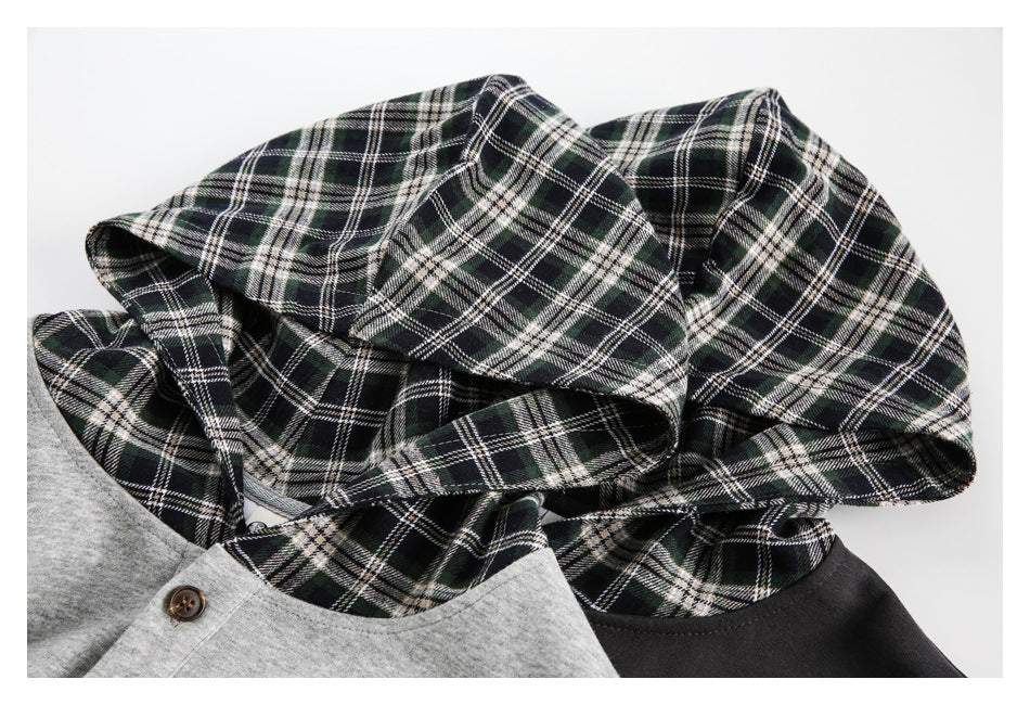 Close-up of the black-and-white plaid hood lining beside charcoal and light gray hoodie fabric.