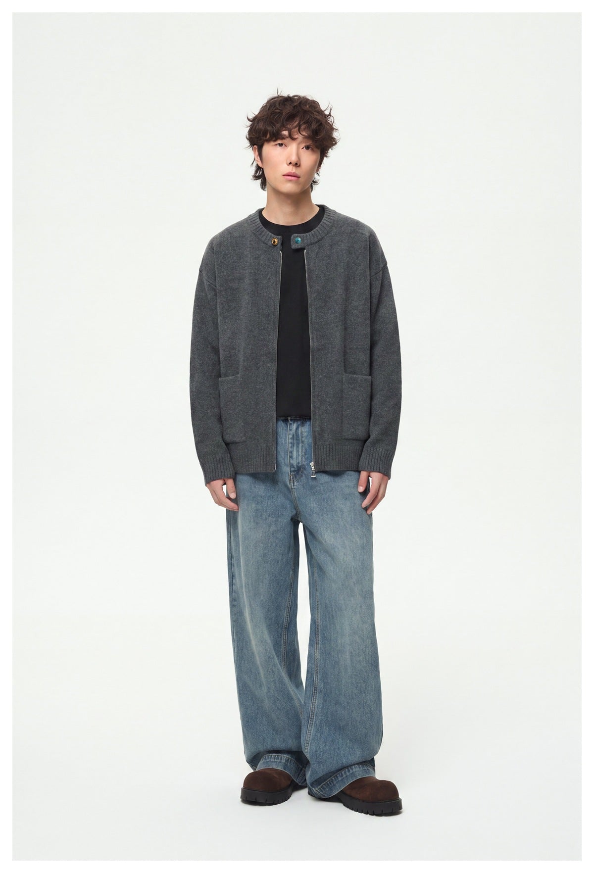 Full-length view of a model wearing a charcoal gray zip-front cardigan with patch pockets and ribbed trim.