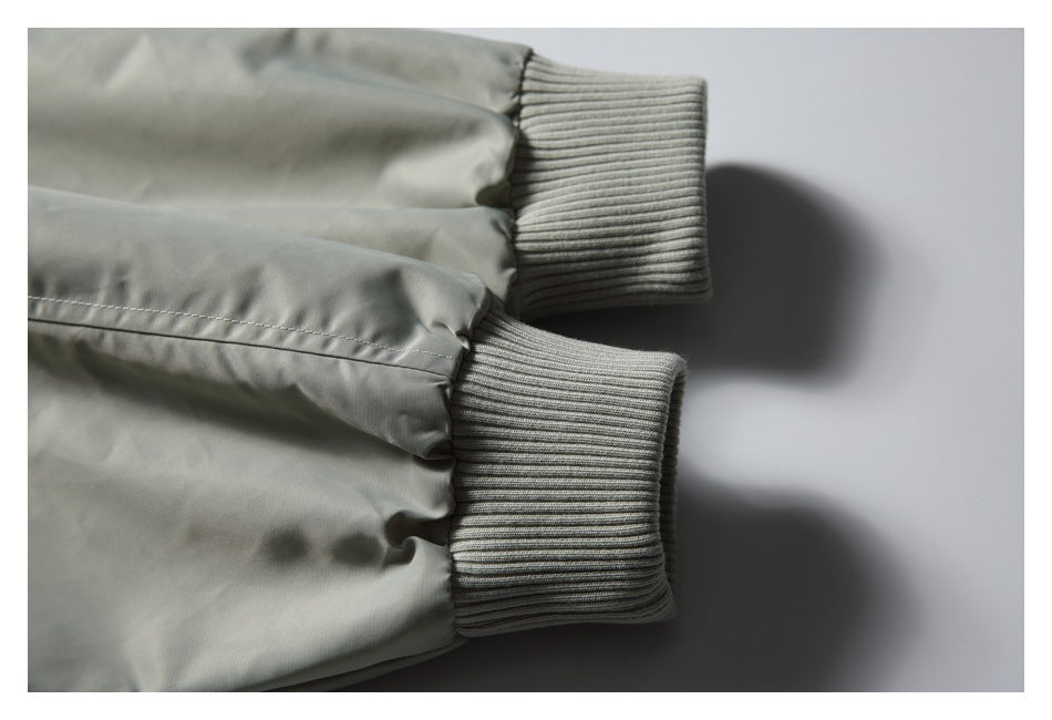Close-up of a light gray jacket sleeve with a wide ribbed knit cuff.