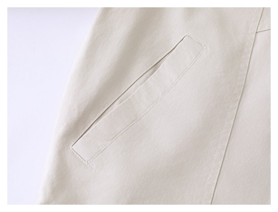 Close-up of a slanted welt pocket on the beige jacket.
