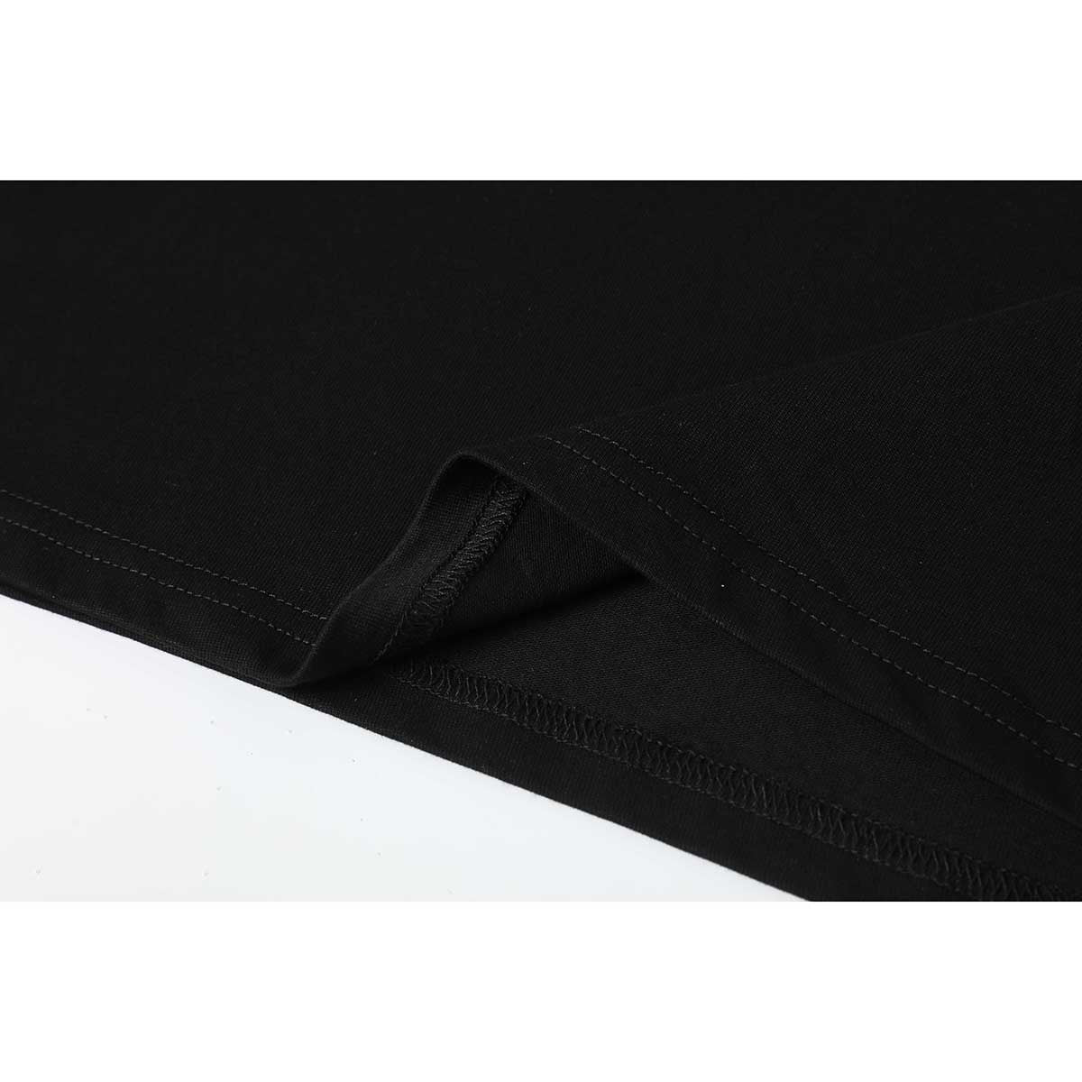 Close-up of the black T-shirt hem showing its folded edge and overlock stitching.