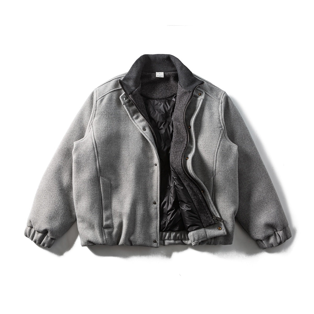 Front view of a gray jacket laid flat and partly open, showing a dark collar, zipper and quilted lining.