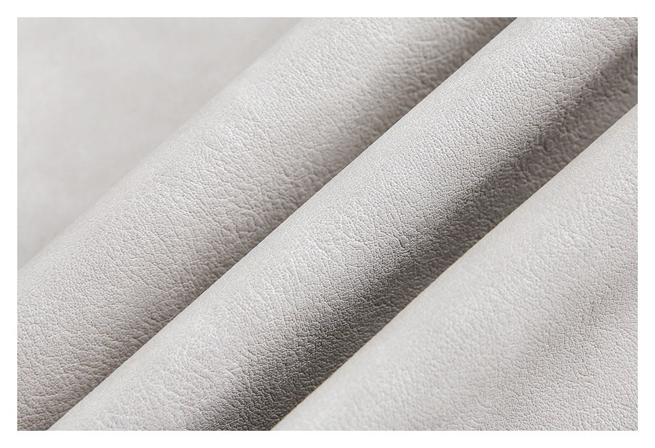 Macro view of the textured surface of light gray fabric folded into ridges.