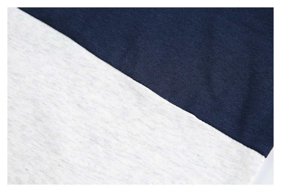 Close-up of the diagonal join between navy and white heathered panels on a shirt.