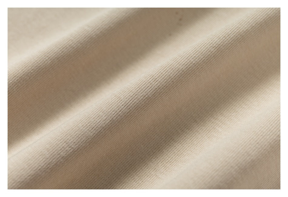 Macro view of the beige garment's fine, ribbed knit texture.