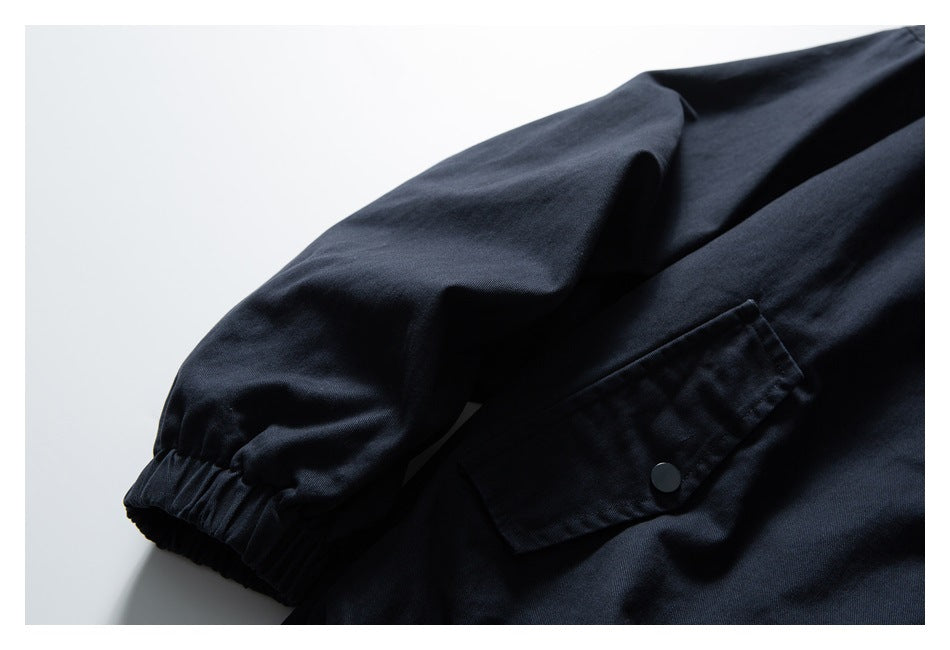 Close-up of the navy jacket's snap pocket and elastic sleeve cuff.