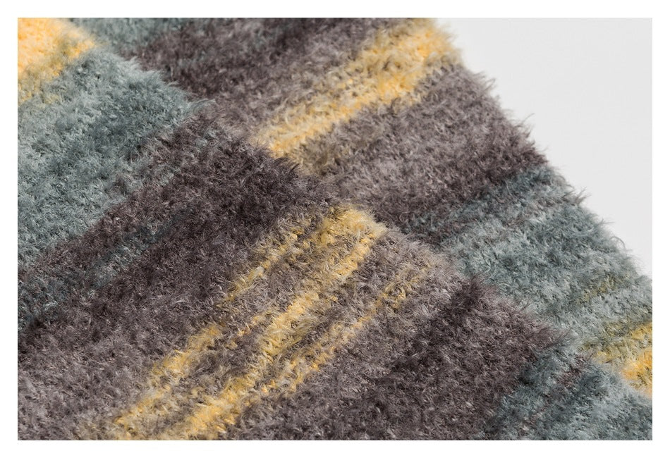 Close-up of the sweater's fuzzy knit and irregular gray, brown, and mustard stripes.