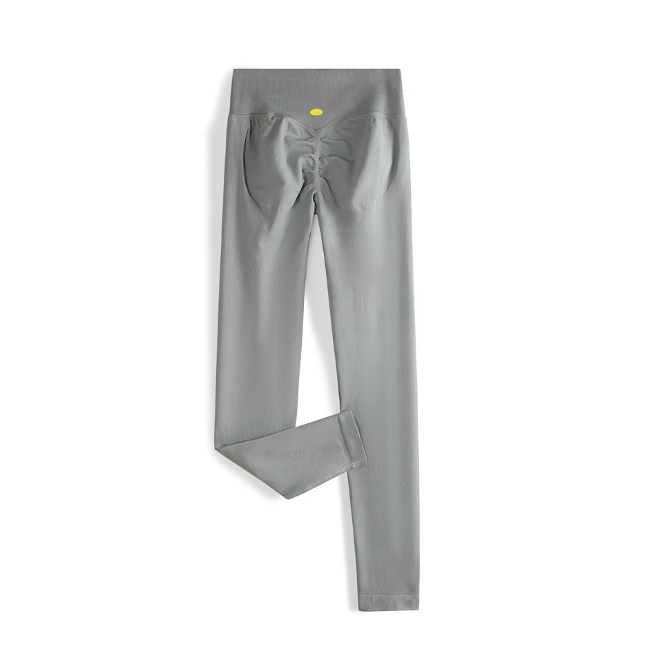 Gray high-waisted leggings shown from the back, with a ruched seat and one leg folded to show the hem.