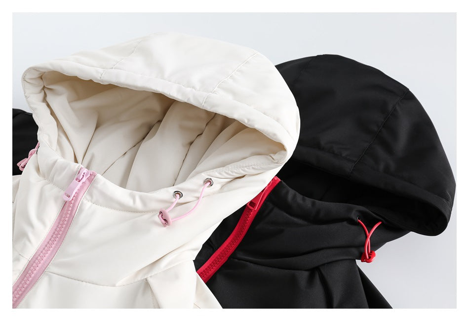 Close-up of white and black jacket hoods with contrasting pink and red zippers and drawcords.