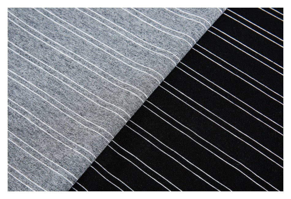 Close-up of gray and black knit fabric colorways with thin white stripes.