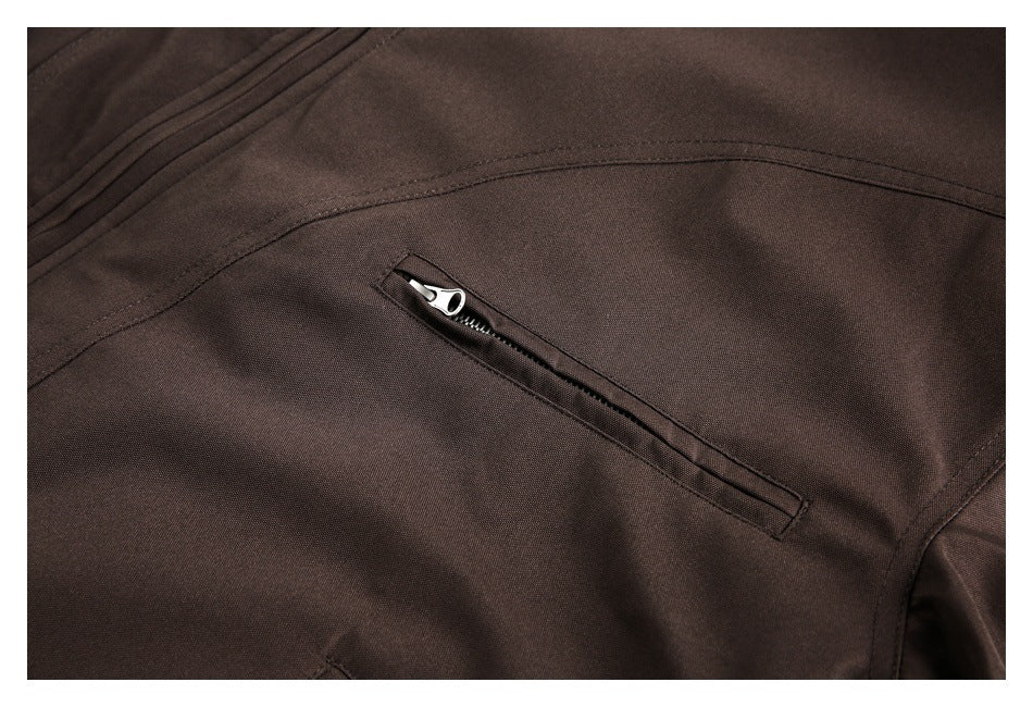 Close-up of a dark brown coat with a narrow zippered pocket and curved stitching.
