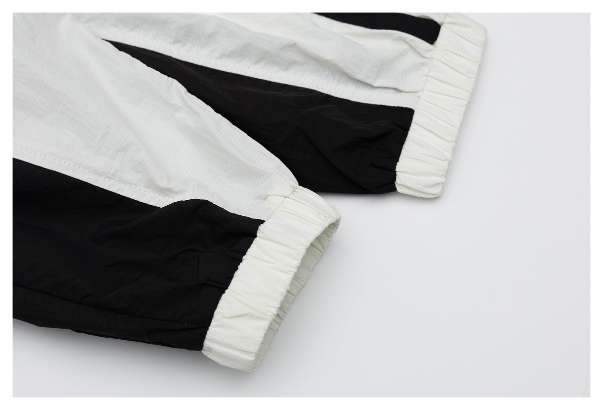 Close-up of black-and-white garment panels meeting at gathered white elastic cuffs.