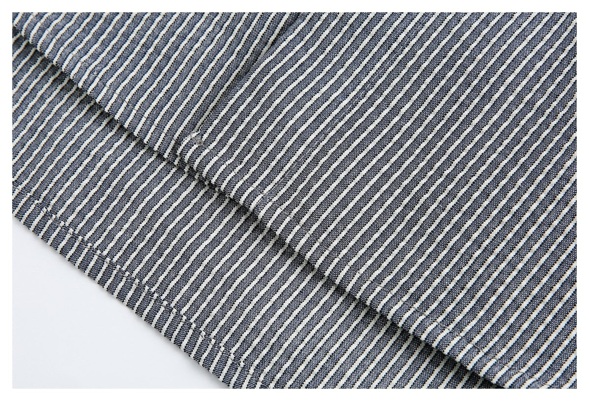 Close-up of a seam and overlapping panels on navy and white striped fabric.