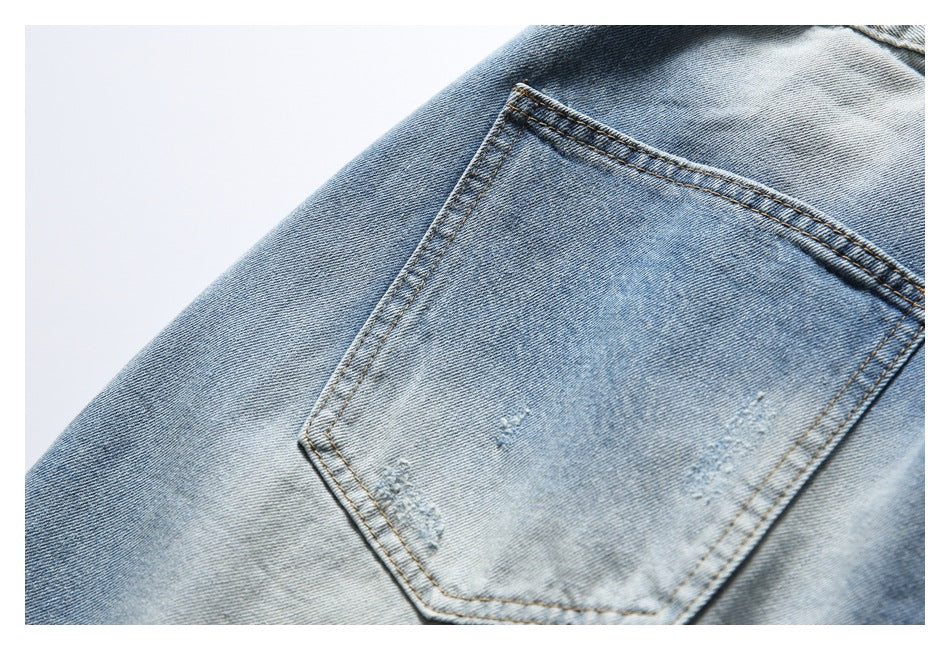 Close-up of a light-wash denim jeans back pocket with contrast stitching and subtle distressed marks.